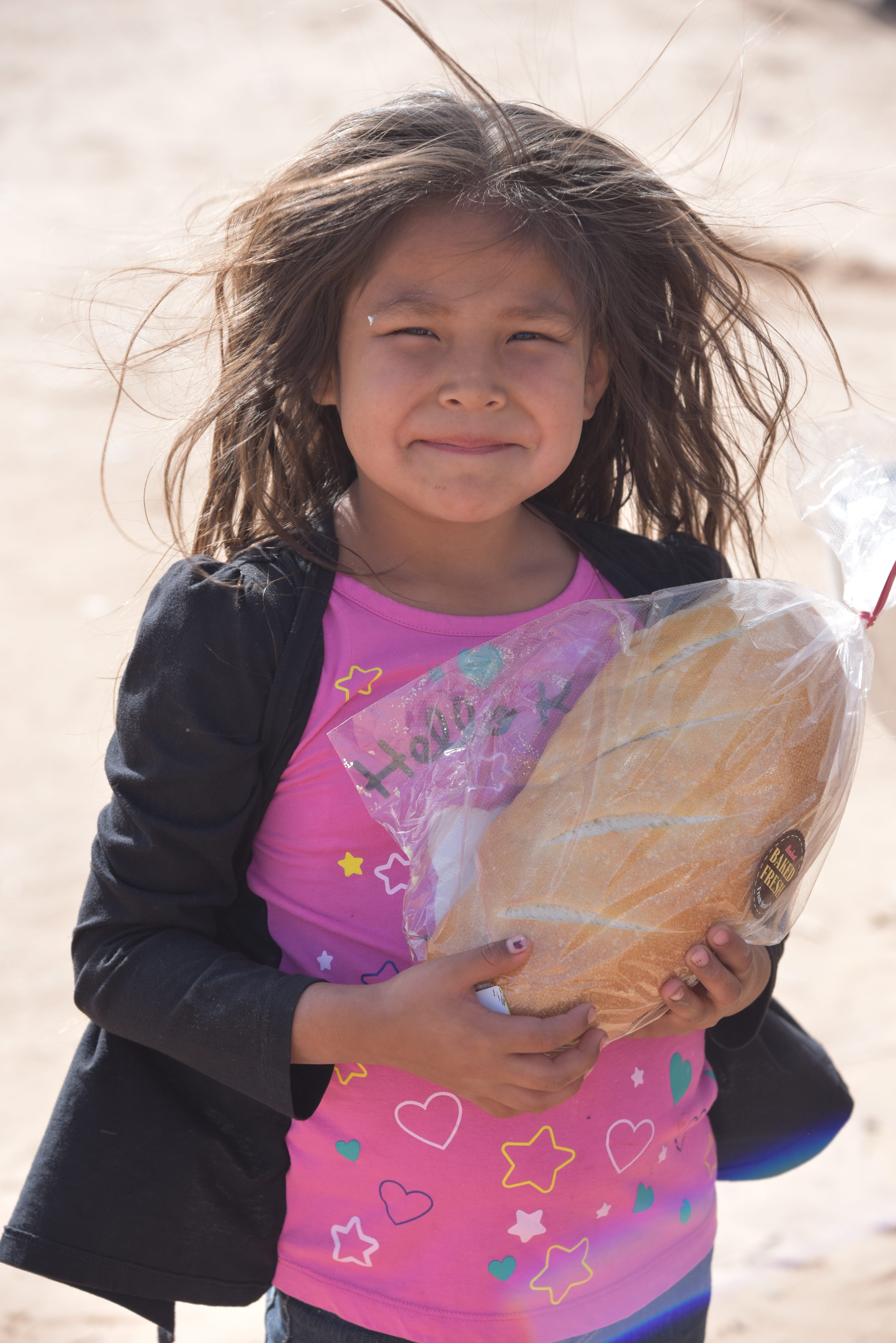 Young girl receiving bread during an Indian Mobile Mission visit