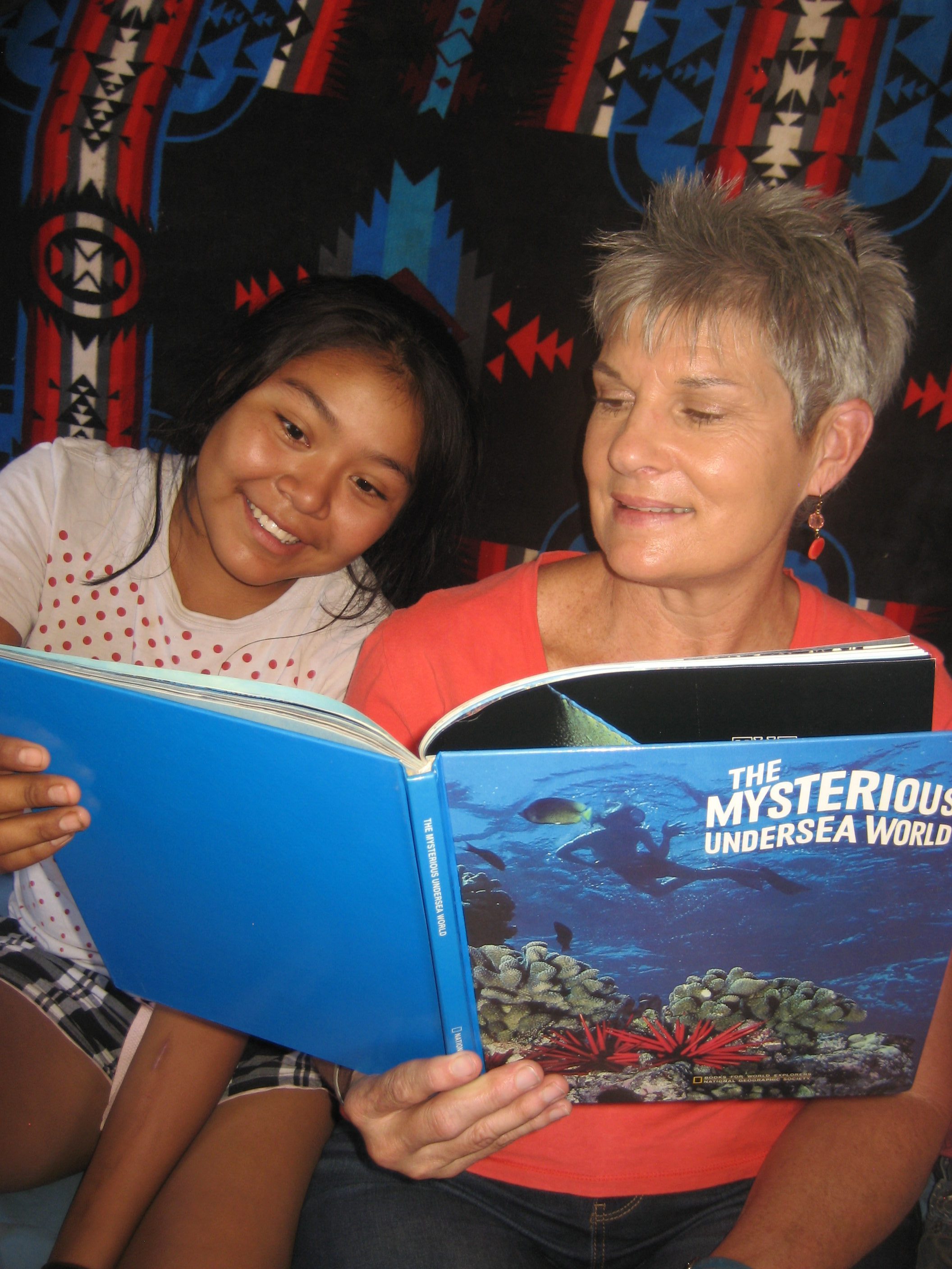 Sylvia reading with a young person during an Indian Mobile Mission visit